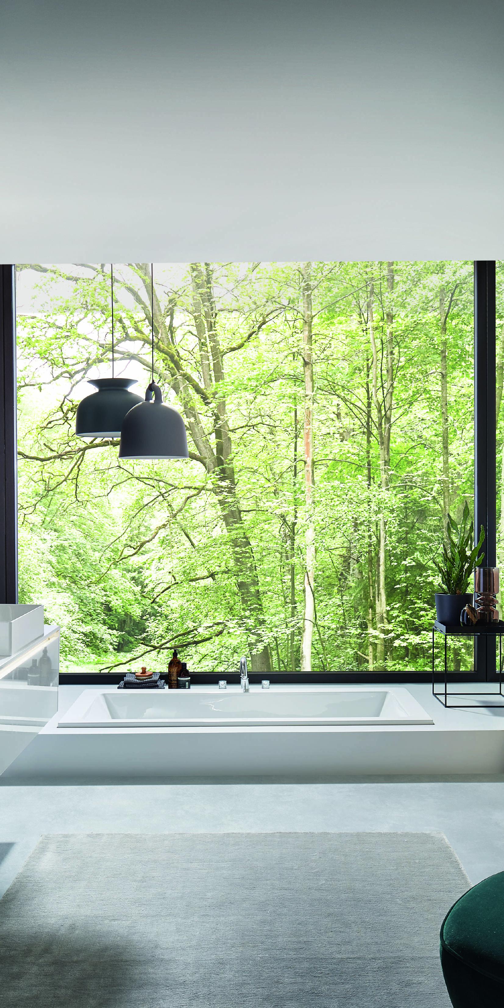 Modernes Badezimmer mit weißen Waschtischen, Badewanne und großer Fensterfront mit Blick ins Grüne